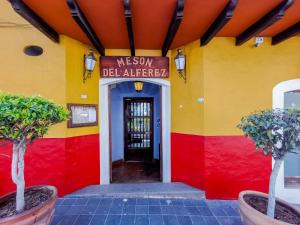 Un edificio rojo, amarillo y rojo con una puerta. en Meson del Alferez Xalapa, en Xalapa