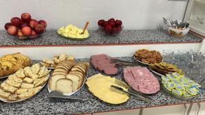 a counter topped with lots of different types of food at Hotel Rota 282 in São Miguel dʼOeste