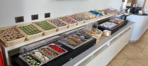 a counter with many baskets of different types of food at Hotel Damanse in Santa Domenica