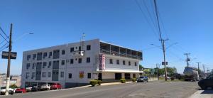 a white building on the corner of a street at Hotel Rota 282 in São Miguel dʼOeste