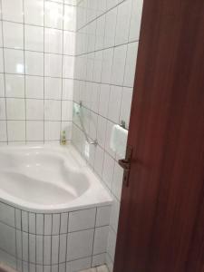 a white bathroom with a tub and a sink at Barun apartman in Lusnić