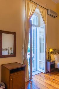 a room with a door open to a bedroom at Archontiko Eleni Hotel in Andros