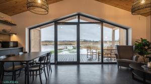 a kitchen and dining room with a view of a deck at Lielpīles in Radziņciems