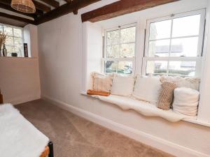 asiento junto a la ventana en una habitación con almohadas blancas en Hall Gowan en Carnforth