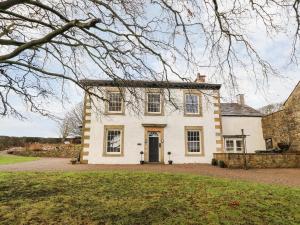 une grande maison blanche avec un arbre dans l'établissement Hall Gowan, à Carnforth