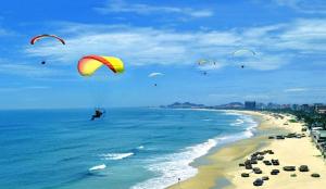 a group of people flying kites over the beach at Beach Hotel by RAON - STAY 24H in Da Nang