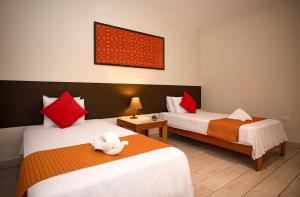 a room with two beds with red and white pillows at Irapay Amazon Lodge in Padre Cocha +88 photos