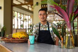 a man standing behind a counter with a basket of food at Irapay Amazon Lodge in Padre Cocha
