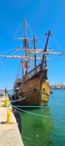 duży drewniany statek siedzący w wodzie w obiekcie Lovely apparment in fornt of the port of Gandia w mieście Los Mártires