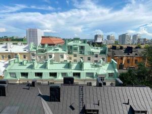 a building with a green roof in a city at Studio apartment, view over the roofs for the sunrise in Helsinki