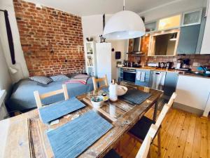 a kitchen with a dining table and a brick wall at Studio apartment, view over the roofs for the sunrise in Helsinki