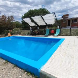 una gran piscina azul con 2 sillas junto a ella en cabañas fátima en Villa Las Rosas