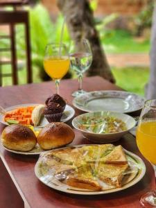 a table with plates of food and glasses of wine at Sky View Cabin Unawatuna in Unawatuna
