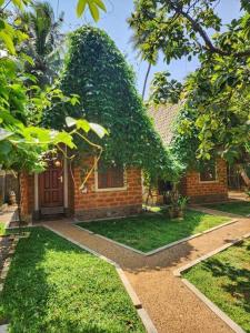 a brick house with a door in a yard at Sky View Cabin Unawatuna in Unawatuna