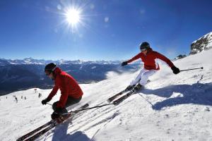 two people are skiing down a snow covered slope at Chambre double privative et indépendante 