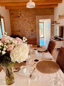 uma mesa de jantar com um vaso de flores em Ses cases noves Llucmajor em Llucmajor