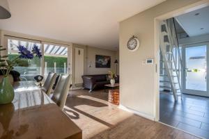 a dining room with a table and a clock on the wall at Moerellahof, Gezin & Familie vakantiehuis aan het Veersemeer ALLEEN GEZINNEN in Wolphaartsdijk