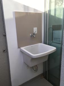 a bathroom with a sink and a glass shower at Loft próximo a UFMS in Campo Grande +11 photos