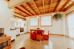 a kitchen with a wooden table and a dining room at Morada Guarda Explorer 01 in Guarda do Embaú +6 photos