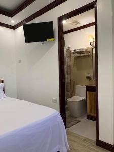 um quarto com uma cama e uma casa de banho com um WC em PEPAYEN INN Homestay em General Luna