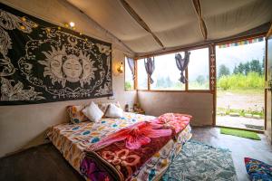 a bedroom with a bed and a large window at Zevibes Cafe & Homestay in Kalgha