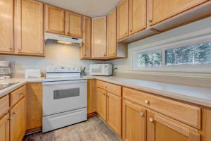 a kitchen with wooden cabinets and a white stove top oven at Carnelian Woods Sanctuary in Carnelian Bay