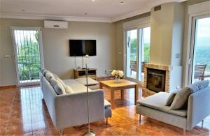 sala de estar con 2 sofás y chimenea en Luxury Villa at La Sella Resort, en Pedreguer