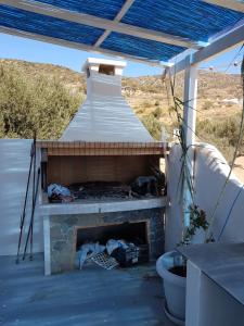 a fireplace on a patio with a roof at Captain Yannis in Sifnos