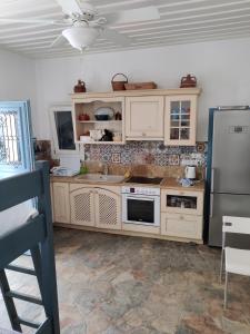 a kitchen with white cabinets and a stainless steel refrigerator at Captain Yannis in Sifnos