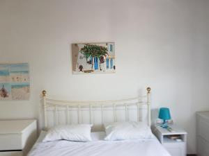 a bedroom with a white bed and a picture on the wall at Captain Yannis in Sifnos