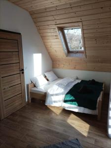 1 dormitorio con 1 cama en una habitación con ventana en Domek nad potokiem, en Grywałd