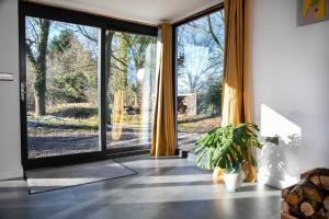 an open glass door in a room with a potted plant at Bird House - Sleep with the Owls! in Carlisle