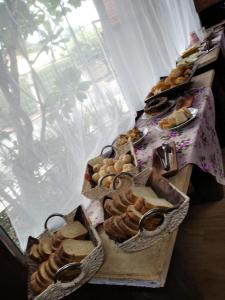 uma mesa coberta com cestas de pão e pastelaria em Pousada Hospede Olimpia em Olímpia