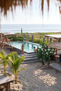 two people in a swimming pool with a waterfall at Casa UwU in Chamuscadero