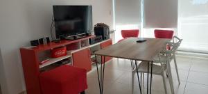 a dining room with a table and a television at Departamento126 in Junín