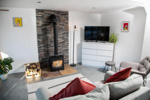 a living room with a fireplace and a tv at Bird House - Sleep with the Owls! in Carlisle