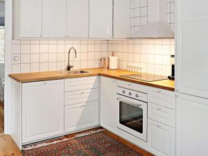 una cocina blanca con armarios blancos y fregadero en Holiday home YNGSJÖ, en Yngsjö