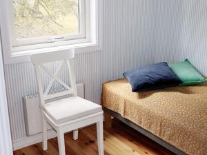 1 dormitorio con silla y 1 cama con ventana en Holiday home YNGSJÖ, en Yngsjö