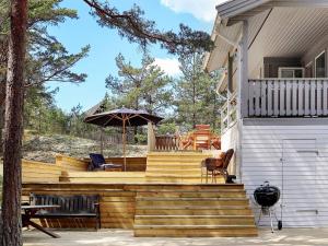 una terraza con sombrilla en una casa en Holiday home YNGSJÖ, en Yngsjö