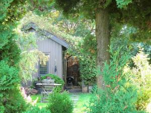 a garden with a table and chairs and a tree at 2 person holiday home in FALKENBERG in Falkenberg