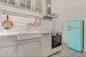 een keuken met witte kasten en een blauwe koelkast bij Byt v harmónii s prírodou in Modra