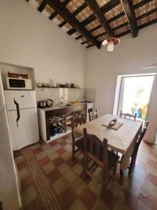 a kitchen with a table and a white refrigerator at Casa Sarmiento in San Francisco del Monte de Oro