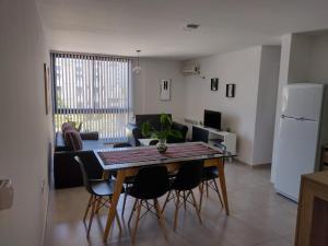 cocina y sala de estar con mesa y sillas en Dto a estrenar Ctro V Carlos Paz en Villa Carlos Paz