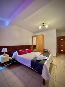 1 dormitorio con 1 cama grande con almohadas rojas en Hotel Feimar, en Cusco