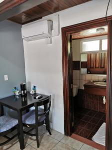 una pequeña mesa y sillas en una habitación con baño en Hotel Puerto San Luis, en Tilarán