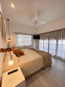 1 dormitorio con 1 cama y ventilador de techo en LA CURVA Casa de Playa en Villa Gesell