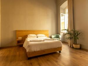 a bedroom with a bed and a potted plant at Esperance 2 in Ermoupoli