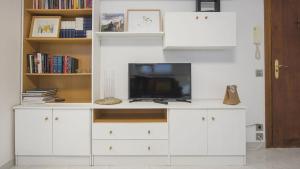 a white entertainment center with a flat screen tv at Casa Recogidas - Apartamentos Aloha Toledo in Toledo