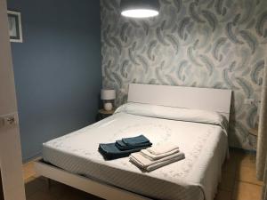 een kleine slaapkamer met een bed met handdoeken erop bij Blue Shades in Bordighera