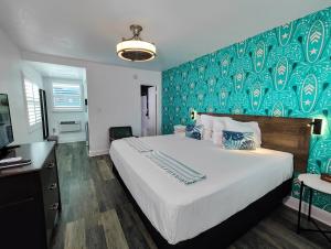 1 dormitorio con 1 cama grande y pared azul en Tahitian Beach Resort, en St Pete Beach